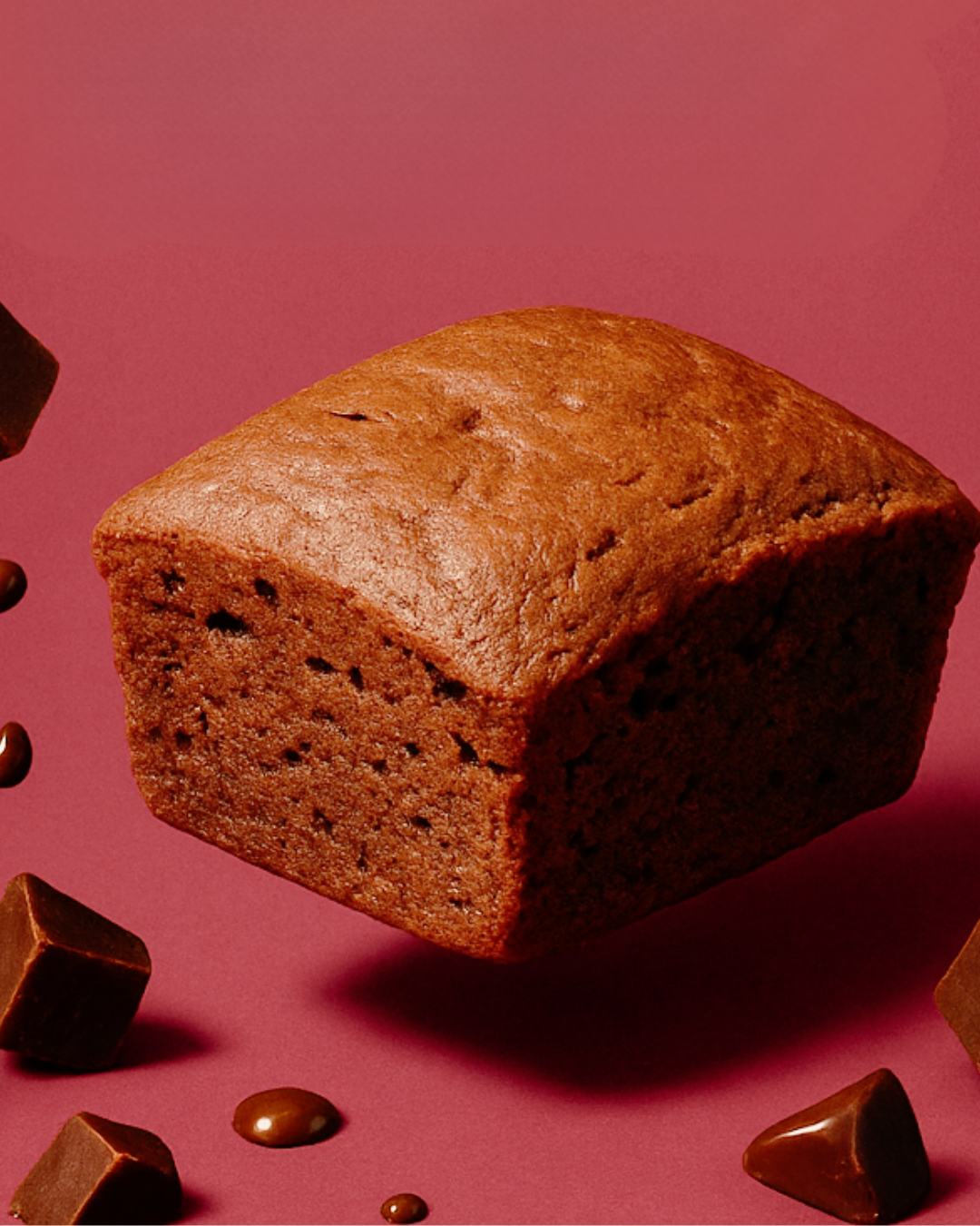 Loaf of bread with chocolate pieces on a pink background